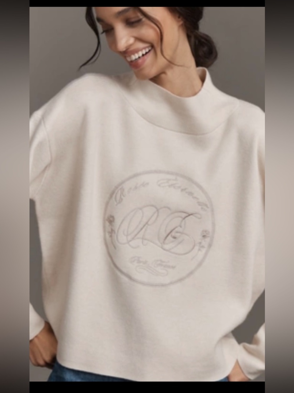 Maeve Cary’s Cream Mock-Neck Logo Sweater